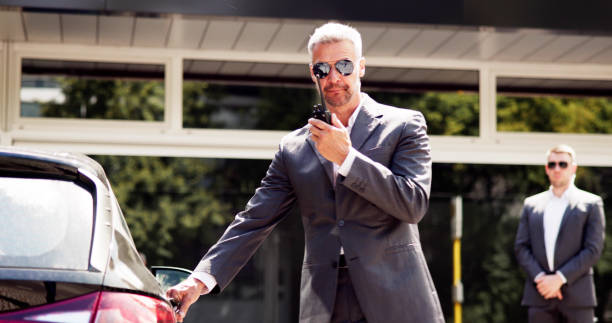 istock Professional bodyguards opening luxury car door 2159608088