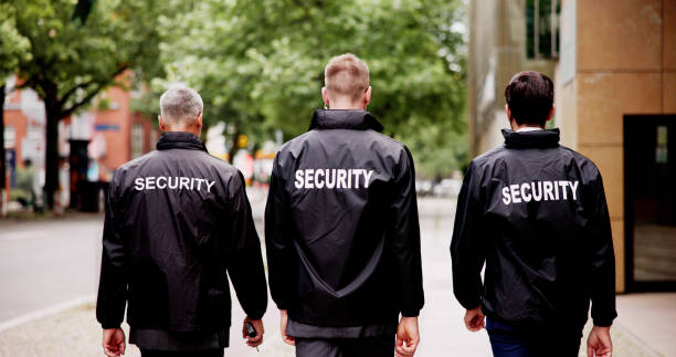 istock Security Guard Event Service: Officer Leading Group on Patrol 2159608096