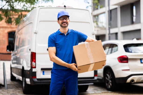 istock Experienced Delivery Man Jovially Moving Cardboard Boxes 2159608127