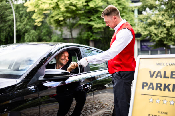 istock Luxury valet service: A man giving his car keys to a valet for parking 2159608154