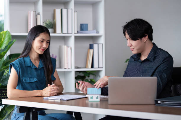 istock Real Estate Agent and Client Signing Home Purchase Contract in Modern Office Setting 2159609398
