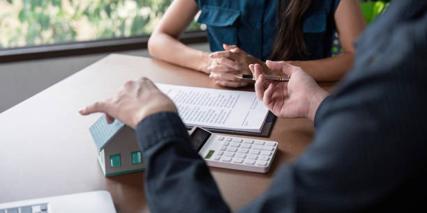 istock Real Estate Agent Discussing Home Purchase Contract with Client at Office Desk 2159609428