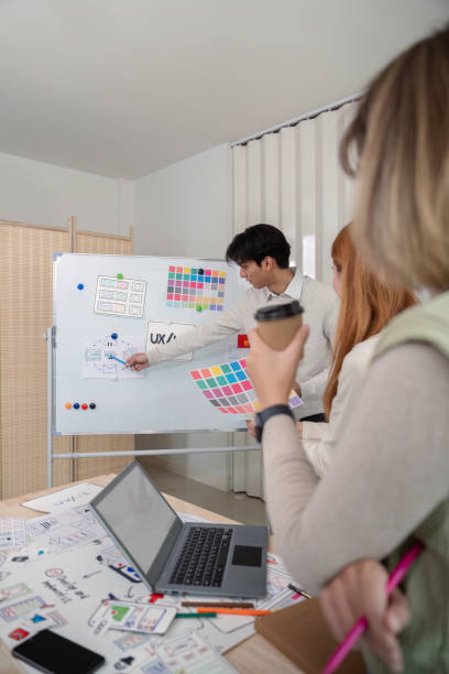 istock Creative UX Developer and UI Designer Brainstorming Session with Color Palettes and Wireframes in Modern Office 2159612283