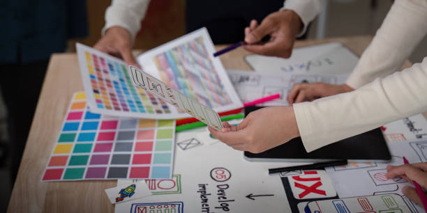istock UX Developer and UI Designer Brainstorming Session with Color Palettes and Wireframes on Desk 2159612406