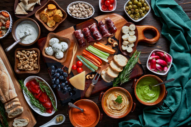 istock Appetizer, cured ham, cheese, nuts and veggies on rustic wooden table with copy space available. 2159612461