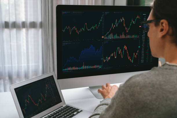 istock Businessman looking to compare with stock of computer and laptop. Pecuniary. 2159612876
