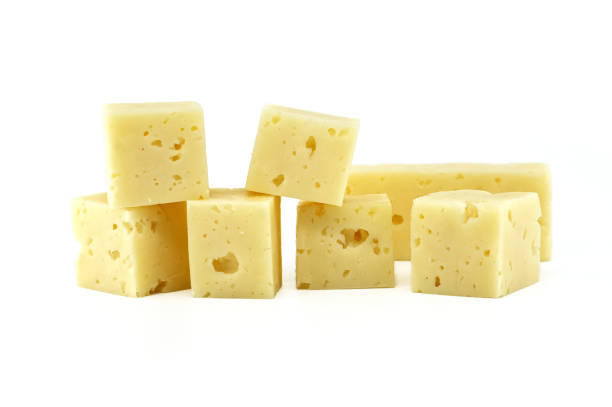 A stack of Swiss cheese cubes arranged neatly, isolated on a white background. Perfect for culinary, cheese, and food-related concepts.