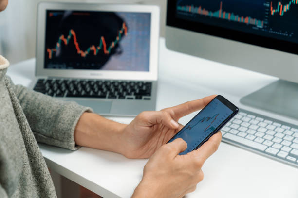 istock Investors pointing on screen with smartphone with laptop in stock. Pecuniary. 2159614277