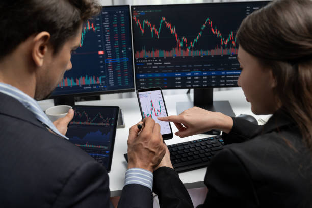 istock Focusing phone with discussing stock market in two business traders. Postulate. 2159616032