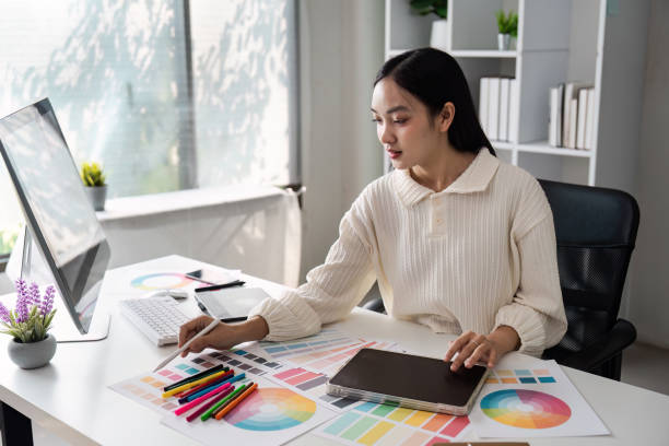 istock Creative Small Business Owner Working on Design Projects in Modern Office Space with Color Swatches and Digital Tools 2159619686