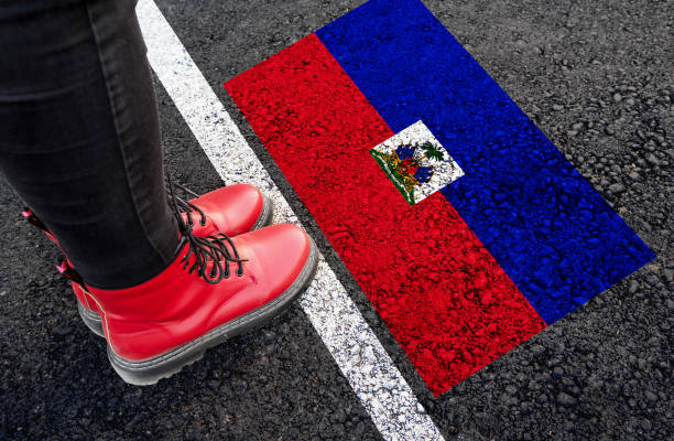 a woman standing next to flag of Haiti stock photo