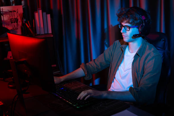 istock Smiling streamer with joystick, focusing Esport team on pc with harder. Gusher. 2159621151