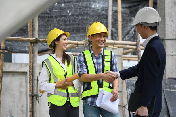 istock Smiling construction manager or engineer shaking hands with investor at building site. Partnership and successful project 2159625231