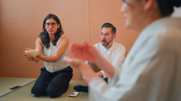 istock Multi-ethnic tourists visiting Japanese tea ceremony master and experiencing and drinking Japanese matcha tea in traditional Japanese tea ceremony room with tatami 2159627370