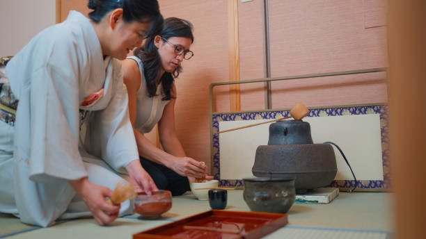 istock Female tourist experiencing Japanese tea ceremony and making her Japanese matcha tea with guidance of female Japanese tea ceremony master 2159627770