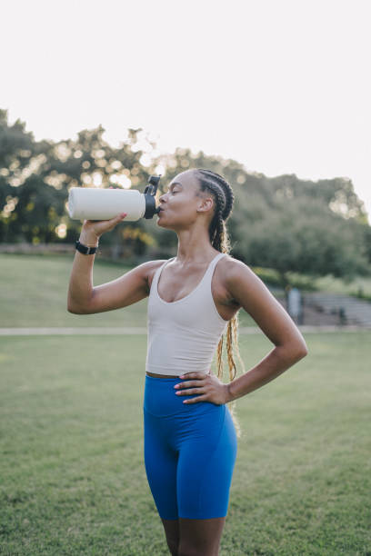 istock Young woman takes a break from exercising to hydrate 2159628459