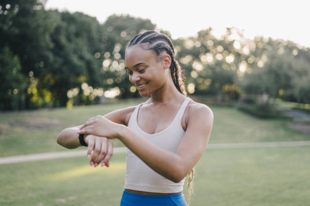 istock Young woman interacts with her smart watch mid-workout 2159628470
