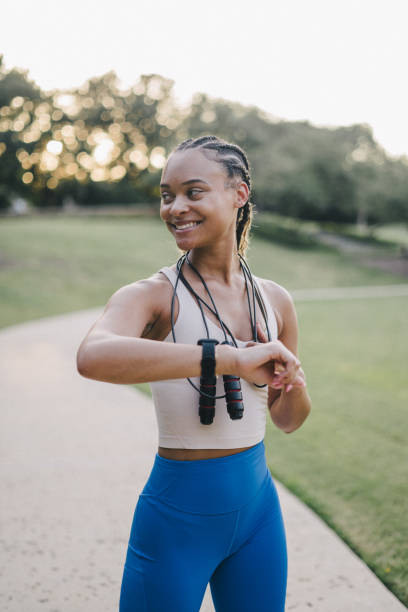 istock Young woman smiles with her smart watch mid-workout 2159628481