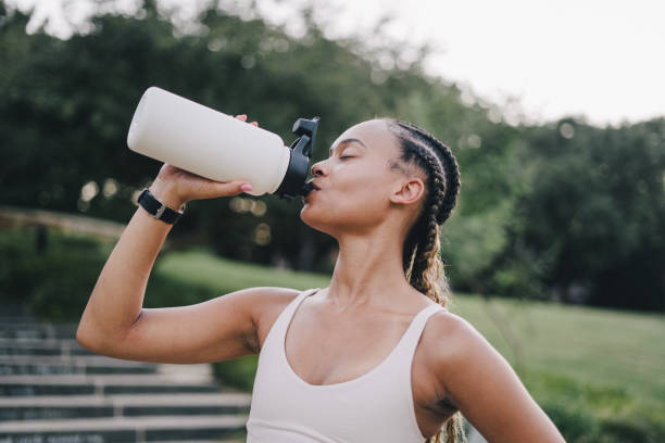 istock Young woman takes a break from exercising to hydrate 2159628525