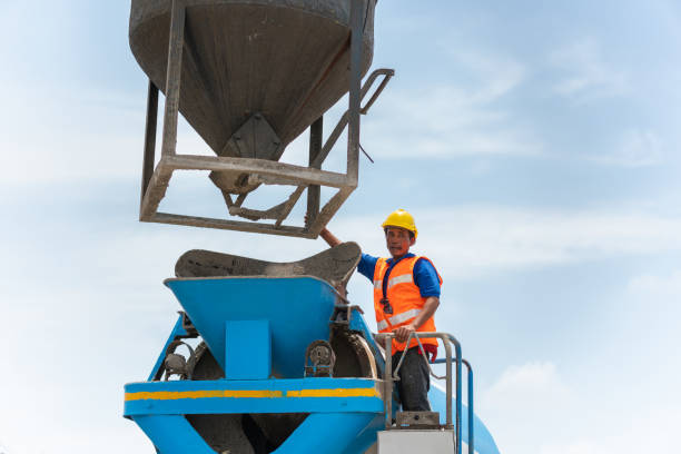 Worker man controls concrete truck mixer on construction site, Foreman at construction site