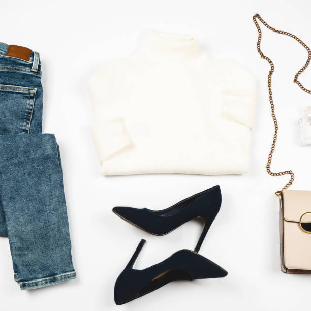 istock flat lay, blue jeans, high heels, sweater, with makeup and accessories on white background, Fashion concept 2159630422