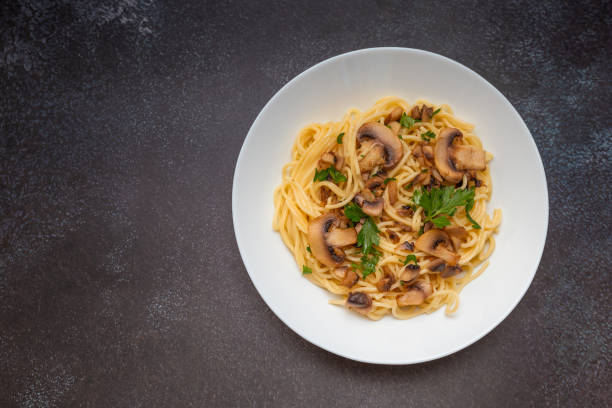 istock Mushroom Spaghetti Pasta and cream sauce on rustic, dark background, top view, copy space. Homemade italian pasta with champignon mushroom. 2159631525