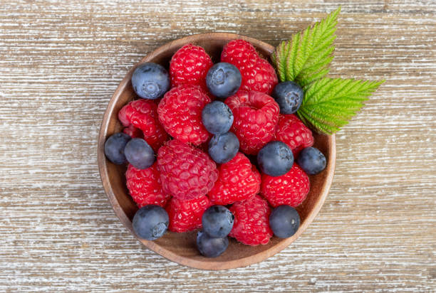 A delightful assortment of fresh blueberries and raspberries artfully arranged on an elegant lace doily