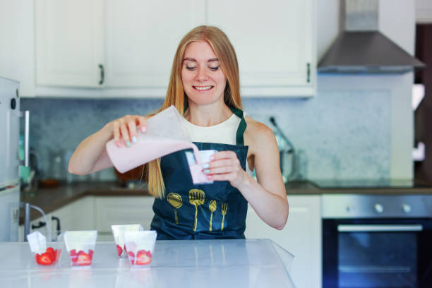 istock girl pours yoghurt dessert into molds 2159633571