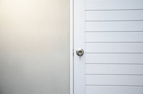 istock Silver knobs and keys on white wooden doors against the gray concrete background for forgot to close the door or lost the key and safety with security concept. 2159637037