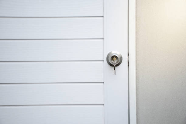 istock Silver knobs and keys on white modern wooden doors against the gray concrete background for forgot to close the door or lost the key and safety with security concept. 2159637063