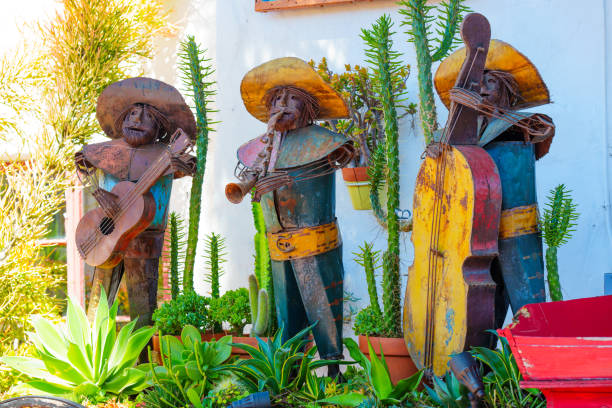 San Diego, California - April 16, 2024: Rustic metal sculptures of three mariachi band musicians playing instruments in a garden setting.