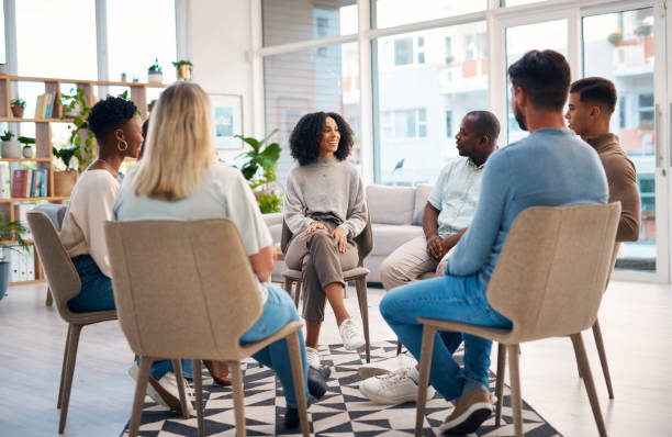 istock A diverse group of individuals participating in a support group session in a bright, modern room. The group members are engaged in conversation, fostering an atmosphere of mutual support, understanding, and connection.Illustrating mental health support 2159641852