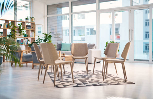 istock A bright and cozy room prepared for a support group session, featuring modern chairs arranged in a circle. The inviting space is designed to encourage conversation, support, and a sense of community among attendees. 2159641876