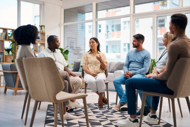 istock A diverse group of people participating in a supportive discussion in a casual and comfortable setting. This image captures a community of individuals sharing and connecting in a warm, light-filled environment. 2159641886