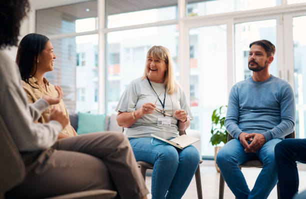 istock A diverse group of people attending a support group meeting in a bright room. The image conveys a sense of community, support, and positive interaction. Individuals are engaged in discussion and sharing experiences. 2159641908