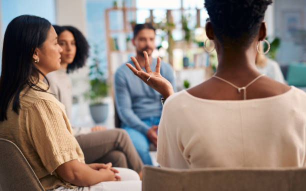 istock A diverse group of people engaged in a support group meeting. The setting appears comfortable with participants seated in a circle, fostering open communication and sharing. Ideal for concepts of community and mental health. 2159641928