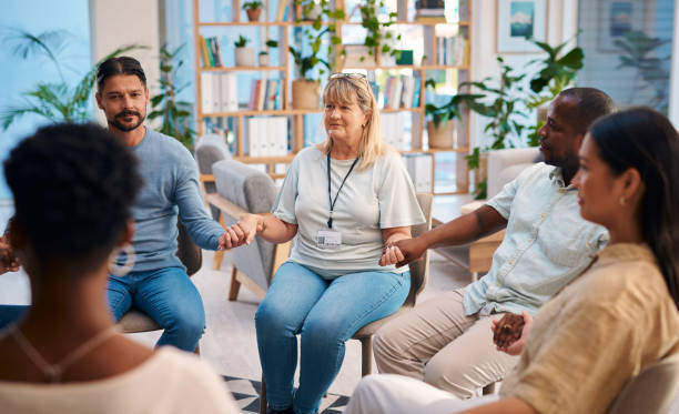 istock A diverse group of individuals sitting in a circle, holding hands, and attending a support group meeting. The scene depicts unity, support, and a safe environment for sharing and healing. 2159641943