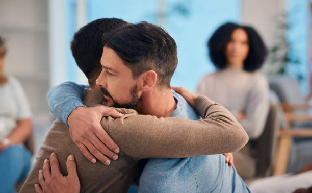 istock Warm Embrace Among Diverse Group In A Support Meeting 2159642015