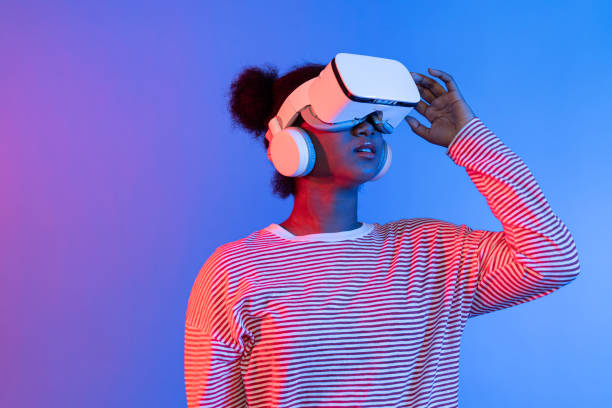 istock Smiling African wearing VR smelling good through meta flower. Contrivance. 2159642587