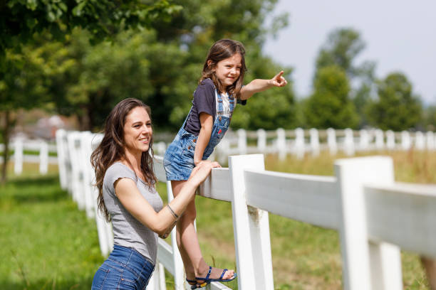 istock Mother and daughter looking at horses 2159646681
