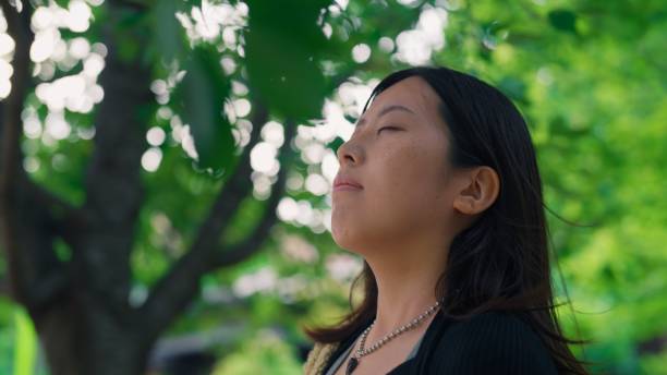 istock Woman relaxing in nature with her eyes closed 2159648217