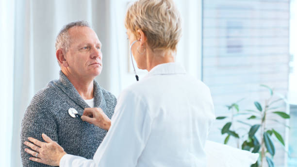 istock A senior female doctor performs a medical examination on an elderly male patient, using a stethoscope to check his heart. The consultation takes place in a well-lit medical office. 2159649710
