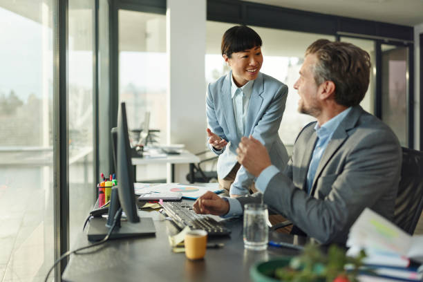 istock Happy business colleagues talking while working in the office. 2159651344