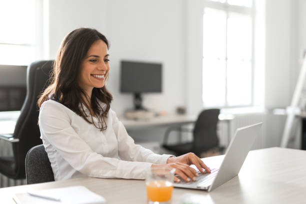 istock Young woman working on her computer in a bright modern office 2159651610