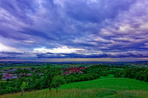 Green fields under cloudy sky on sunny day