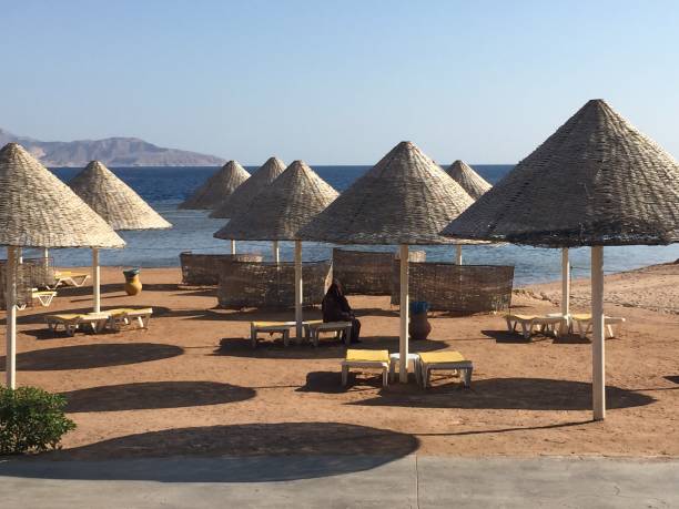 istock Beach with pergola umbrellas and mountain view 2159653911
