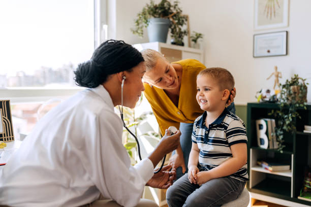 istock Cute boy getting examined by paediatrician at the doctor's office while his mother is standing next to him 2159654581