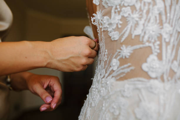istock Wedding preparation, wedding gown being tied up 2159654747