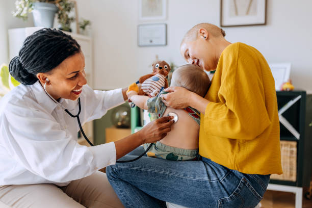 istock Female paediatrician examining cute little baby boy with stethoscope while he is being held by his mother at doctor's office 2159655178