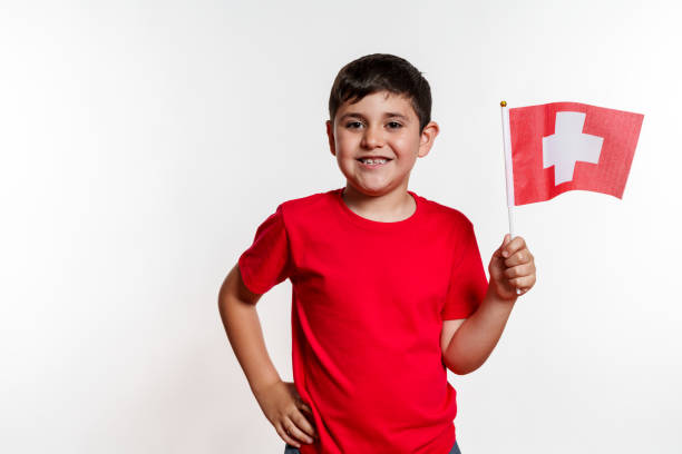 istock A young boy is holding a red Swiss flag and smiling 2159655307